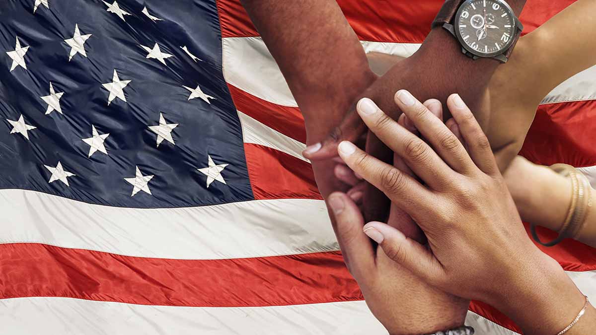 Diverse hands in front of a USA flag